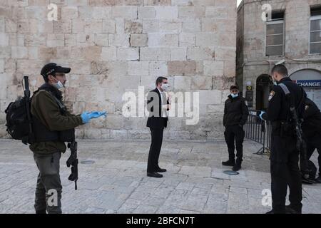 Israelische Polizisten verhindern die Durchreise eines religiösen Juden mit Schutzmaske wegen der COVID-19-Coronavirus-Pandemie an einem Kontrollpunkt im Jaffa-Tor in der Altstadt von Jerusalem. Israel verhängte eine strengere Blockierung der Stadtteile Jerusalems mit einem hohen Prozentsatz der Fälle von Coronavirus. Die Stadt ist in "eingeschränkte" und nicht-eingeschränkte Zonen unterteilt. Stockfoto