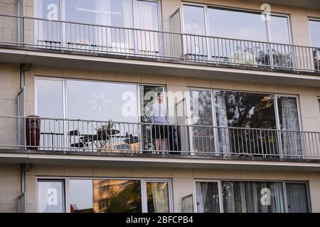 Brüssel, Belgien. April 2020. Ein Mann blickt auf die Landschaft auf dem Balkon in Brüssel, Belgien, 17. April 2020. Seit Belgien am 18. März Sperrmaßnahmen zur Eindämmung der Ausbreitung des neuartigen Coronavirus ergriffen hat, ist ein Monat vergangen. Die belgische Ministerpräsidentin Sophie Wilmes kündigte am 15. April eine Verlängerung der Lockdown bis zum 3. Mai an. Kredit: Zhang Cheng/Xinhua/Alamy Live News Stockfoto