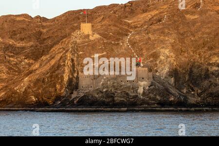 Fort mit Bergen im Hintergrund und am Wasser beim Sonnenuntergang Stockfoto