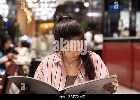 Asiatische schöne Frau Bestellung von der Speisekarte im Luxus-Restaurant. Stockfoto