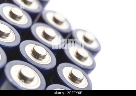 Batterien in Reihen. Nahaufnahme oder Makro der Pluspole von blauen AA-Alkali-Batterien. Isoliertes Bild mit selektivem Fokus und Kopierbereich. Stockfoto