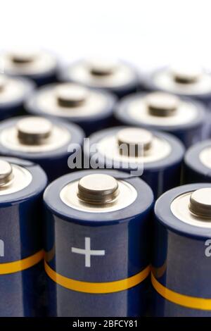 Batterien in Reihen. Nahaufnahme oder Makro der Pluspole von blauen AA-Alkali-Batterien. Vertikales Bild mit selektivem Fokus und Kopierbereich. Stockfoto