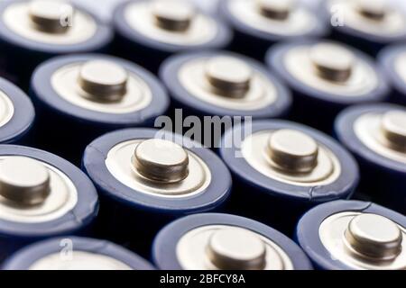 Batterien in Reihen. Nahaufnahme oder Makro der Pluspole von blauen AA-Alkali-Batterien. Bild mit selektivem Fokus. Stockfoto