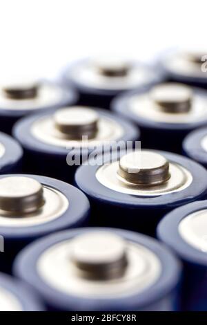 Batterien in Reihen. Nahaufnahme oder Makro der Pluspole von blauen AA-Alkali-Batterien. Vertikales Bild mit selektivem Fokus und Kopierbereich. Stockfoto