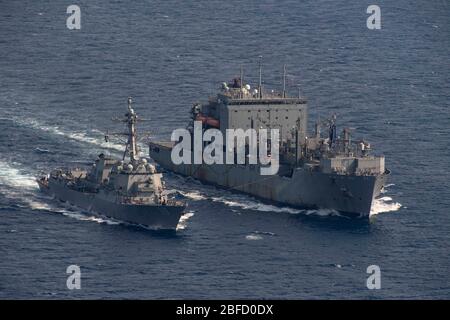 PAZIFIK (17. April 2020) der US-Navy Arleigh Burke-Klasse-Raketenlenker USS Rafael Peralta (DDG 115) und das Military Sealift Command Dry Cargo and Munitionship Ship USNS Washington Chambers (T-AKE 11) führen eine Auffüllung auf See durch. Rafael Peralta wird im 7. Flottenbereich der USA eingesetzt, um die Sicherheit und Stabilität in der Region Indo-Pazifik zu unterstützen. (USA Navy Foto von Mass Communications Specialist 2. Klasse Jason Isaacs) Stockfoto