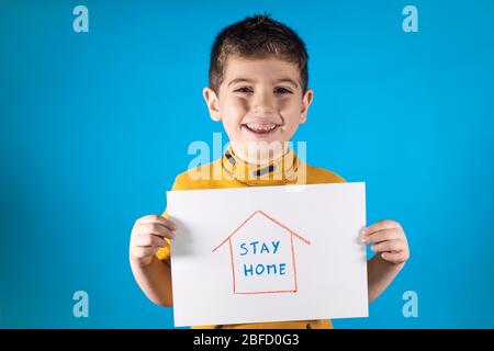 Kleines Kind zeigt eine Zeichnung für „Stay Home“ Stockfoto