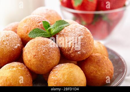 Wunderschönes Frühstück. Hüttenkäse Donuts Kugeln auf einem hellen Hintergrund Nahaufnahme. Stockfoto
