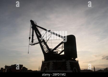 Eine Silhouette des historischen Armstrong Mitchell Crane, der im Arsenale in Venedig installiert wurde Stockfoto