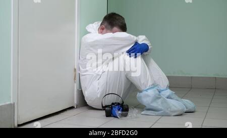 Mittlere Aufnahme. Doktor Mann, der eine Pause auf dem Boden eines Krankenhauses sitzt. Professionelle Aufnahme in 4K-Auflösung. 054. Sie können es z.B. in Ihrem comer verwenden Stockfoto