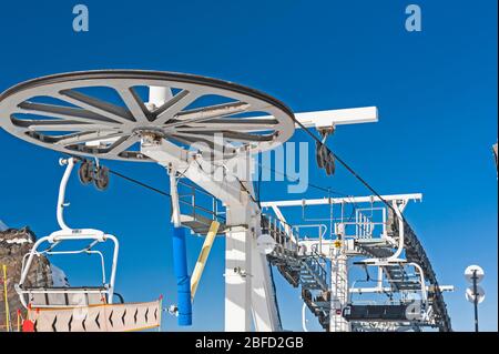 Spitze eines alpinen Sessellifts auf Berg im Skigebiet mit großem Riemenscheibe Stockfoto