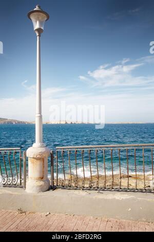 Laternenpfosten entlang der Küste von Qawra Teil von Saint Pauls Bay in Malta Stockfoto