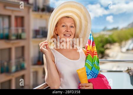 Erwachsene Tourist Frau in Hut auf dem Balkon im Hotel in der Nähe des Meeres.Urlaub im Resort-Konzept Stockfoto