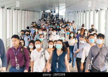 BANGKOK, THAILAND - MAR 2020: Menschenmenge von nicht erkennbaren Geschäftsleuten, die eine chirurgische Maske tragen, um einen Ausbruch von Coronavirus in der Hauptverkehrszeit zu verhindern Stockfoto