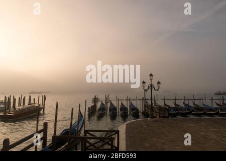 Gondeln gesehen an einem nebligen Morgen, entlang der Pier im Canal Grande in Venedig, Italien. Stockfoto