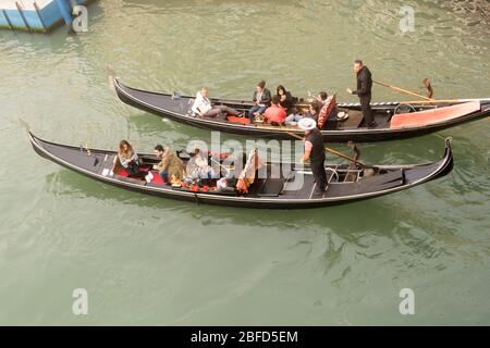 Touristen genießen eine Fahrt mit der Gondel entlang des Canale Grande in Venedig, Italien Stockfoto