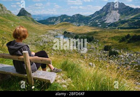Frau auf Holzbank und malerische Sommer Berglandschaft des Durmitor Nationalpark, Montenegro, Europa, Balkan Dinarischen Alpen, UNESCO World Heri Stockfoto