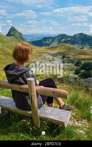 Frau auf Holzbank und malerische Sommer Berglandschaft des Durmitor Nationalpark, Montenegro, Europa, Balkan Dinarischen Alpen, UNESCO World Heri Stockfoto