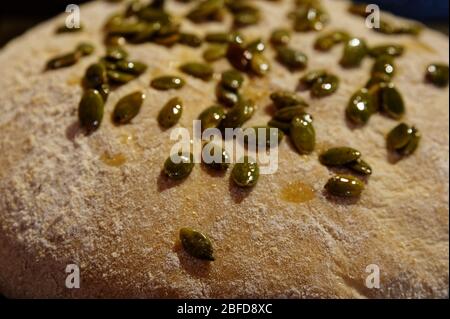 Brotteig, der jetzt für den Ofen bereit ist, hat Kürbiskerne auf der Oberseite Stockfoto