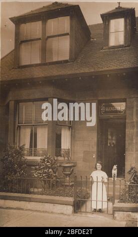 Britische Fotokarte aus dem frühen 20. Jahrhundert zeigt ein Haus namens Glenearn. Eine Dame und ihr Hund standen vor der Vorderseite des Grundstücks. Stockfoto