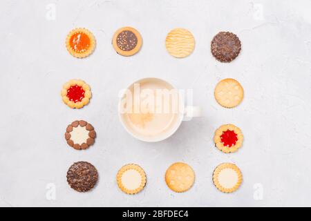 Quadratischer Rahmen aus Cookies mit Kaffeetasse innen mit freiem Platz innen auf weißem Hintergrund. Platz für Text. Ein herzlicher Gruß. Kopierbereich Stockfoto