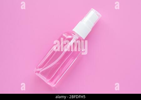 Kosmetische Flasche mit Handdesinfektionsmittel, antiseptisches Spray zur Desinfektion. Remover Flüssigkeit in Behälter auf einem rosa Hintergrund. Reinigungsmittel Stockfoto