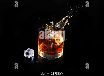Whiskey-Spritzer mit Eis auf schwarzem Hintergrund isoliert Stockfoto