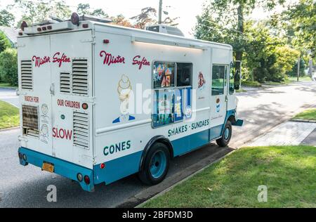 Babylon, New York, USA - 30. September 2018: Ein LKW von Mister Softee fährt eine Straße in einem Wohnviertel entlang und verkauft Eis und Shakes. Stockfoto