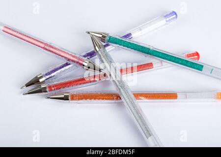 Eine Auswahl an farbigen Glitter-Gel-Stiften auf weißem Hintergrund Stockfoto