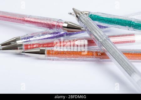 Eine Auswahl an farbigen Glitter-Gel-Stiften auf weißem Hintergrund Stockfoto