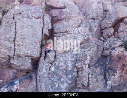 Junge Sportliche Frau Klettern auf Bergklippe mit schöner Landschaft im Hintergrund. Gesunder Lebensstil. Active Extreme Stockfoto