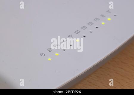 Es gibt ein weißes vdsl-Modem und grüne Lichter und Symbole auf ihm. Nahaufnahme. Stockfoto