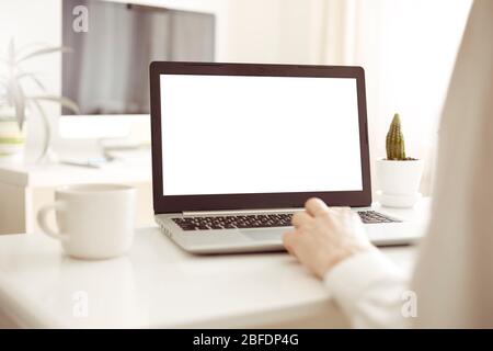 Laptop-Monitor mit weißem Bildschirm auf dem Desktop eines Freiberufler. Leerer Bildschirm. Stockfoto