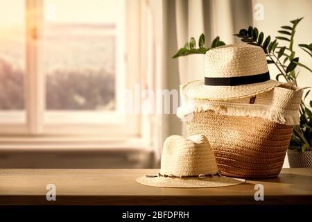 Holztisch mit Tasche und Kleidung und Kopierraum für Produkte. Schönes gemütliches und helles Zuhause. Hintergrund des Fensters mit natürlichem Licht. Stockfoto