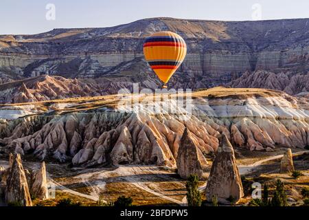 Bunte Heißluftballons fliegen über das Tal in Kappadokien, Anatolien, Türkei. Vulkanberge im Nationalpark Göreme. Stockfoto
