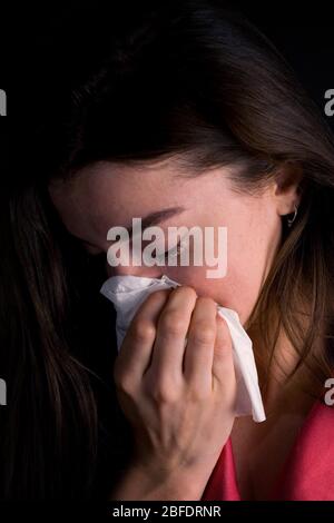 Junge Frau niesen in ein Gewebe -Modell freigegeben