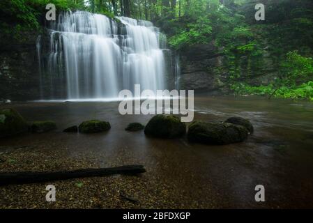 Ein Wasserfall steigt in eine grüne Schlucht in den Wäldern von Südengland (Glen Falls, Portland, Connecticut). Stockfoto