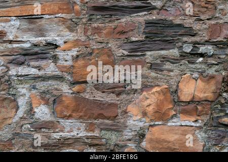 Detailansicht der freiliegenden rauen alten Ziegelstein- und Steinmauer Stockfoto