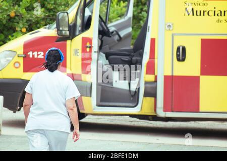 Murcia, Spanien, 18. April 2020: Ärzte mit Schutzanzug in einem spanischen Krankenwagen wegen Coronavirus. Notdienste, die covid Tests in Home de Stockfoto