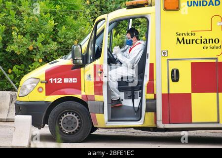 Murcia, Spanien, 18. April 2020: Ärzte mit Schutzanzug in einem spanischen Krankenwagen wegen Coronavirus. Notdienste, die covid Tests in Home de Stockfoto