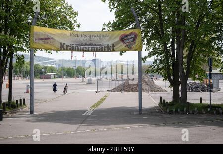 Stuttgart, Deutschland. April 2020. Ein Fußgänger und ein Radfahrer sind auf dem Weg zur Wasengelande, wo normalerweise das Stuttgarter Frühlingsfest stattfindet. Das Stuttgarter Frühlingsfest sollte am 18. April begonnen haben und wurde wegen der Corona-Pandemie abgesagt. Quelle: Marijan Murat/dpa/Alamy Live News Stockfoto