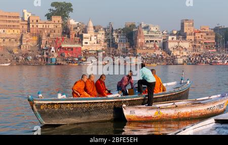 VARANASI, UTTAR PRADESH / INDIEN - APRIL 2019 : Boote, die im Ganges in der Nähe von Varanasi Ghats herumlaufen Stockfoto