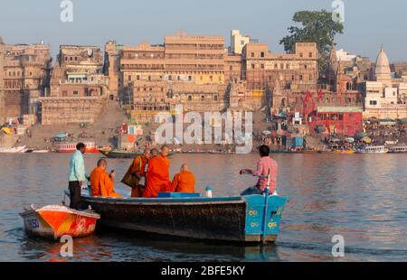 VARANASI, UTTAR PRADESH / INDIEN - APRIL 2019 : Boote, die im Ganges in der Nähe von Varanasi Ghats herumlaufen Stockfoto