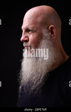 Reife kahlbärtige Mann vor schwarzem Hintergrund Stockfoto