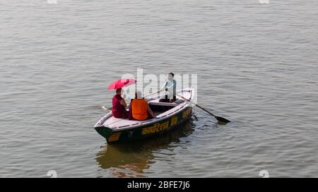 VARANASI, UTTAR PRADESH / INDIEN - APRIL 2019 : Boote, die im Ganges in der Nähe von Varanasi Ghats herumlaufen Stockfoto