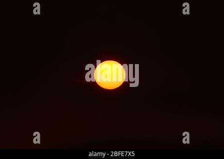 Orangefarbene Sonne im dunklen Sonnenuntergang Himmel Stockfoto