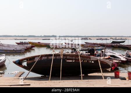 VARANASI, UTTAR PRADESH / INDIEN - APRIL 2019 : Boote, die im Ganges in der Nähe von Varanasi Ghats herumlaufen Stockfoto