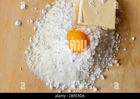 Produkte für Teig, Mehl, Zucker und Eier auf dem Brett. Hausgemachtes Gebäck. Shortbread. Butterkeks Stockfoto