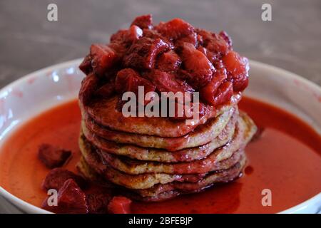 Stapel von veganen Pfannkuchen mit hausgemachter Erdbeersauce. Leckeres und gesundes hausgemachtes Frühstück. Stockfoto