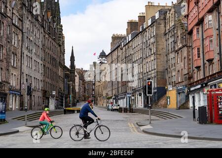 Edinburgh, Schottland, Großbritannien. 18. April 2020. Blick auf leere Straßen und die Öffentlichkeit an einem weiteren Samstag während der Sperrung des Coronavirus in Edinburgh. Familienradeln vorbei an der Royal Mile. Iain Masterton/Alamy Live News Stockfoto