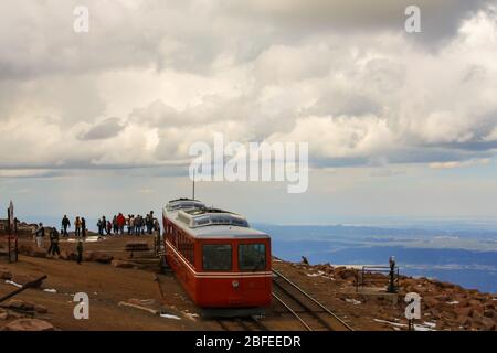 Zahnradbahn Kutsche auf dem Gipfel des Pikes Peak in Rocky Mountains mit Touristen Sightseeing Schlange an Bord roten Zug. Colorado USA Stockfoto